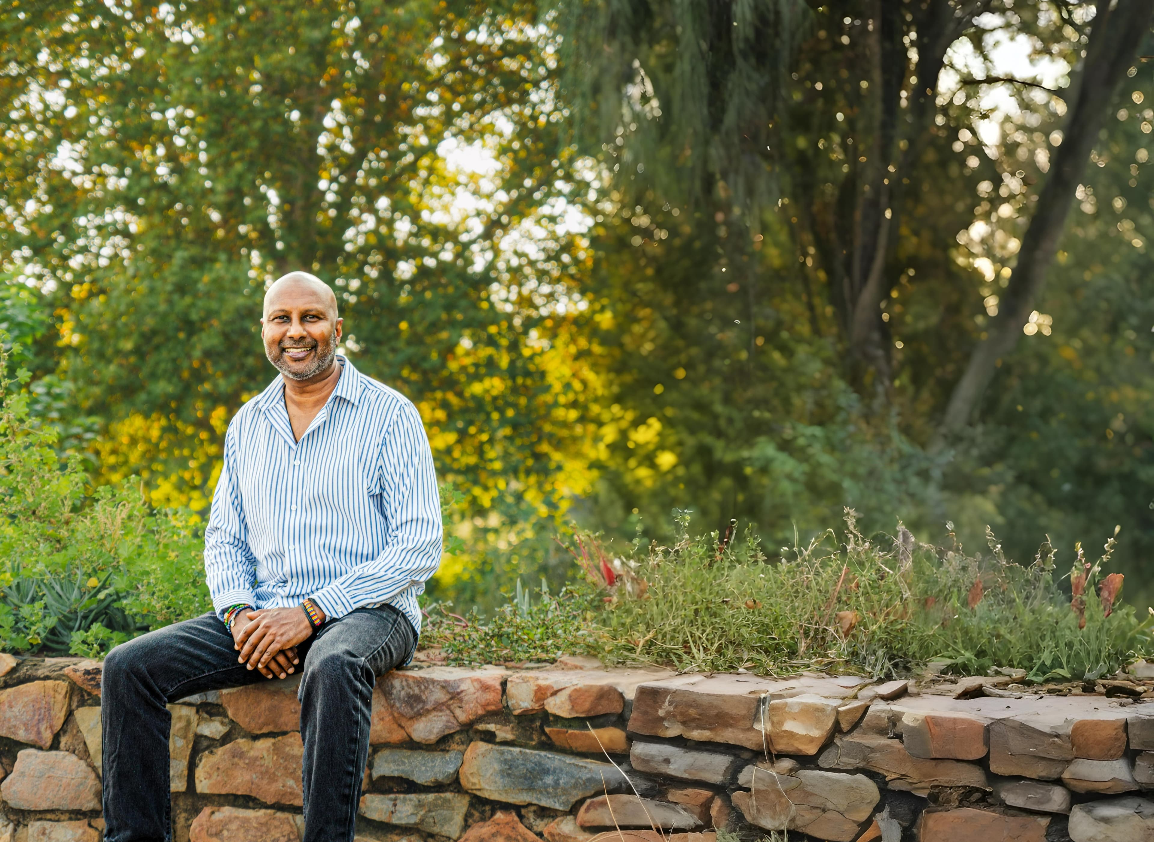 Wayne Simon seated on rocks outdoors